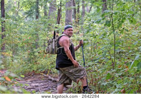 Man Wearing A Backpack & Hiking On A Nature Trail