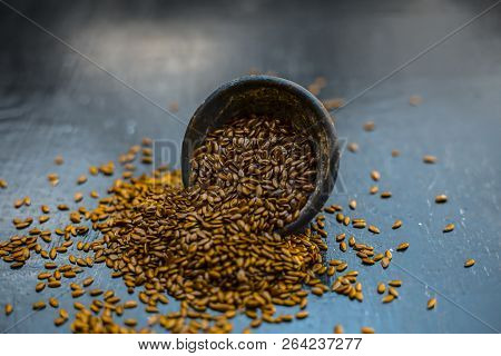 Close Up Of Ayurvedic Herb Alsi Or Adsi Or Flax Seed In A Black Colored Clay Bowl On Wooden Surface