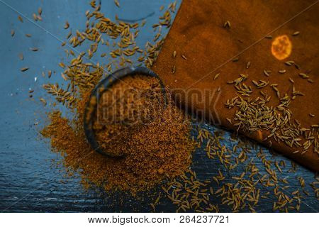Close Up Of Powdered Cumin Or Zeera Or Jeera With Raw Cumin On Wooden Surface In A Clay Bowl On A Cl