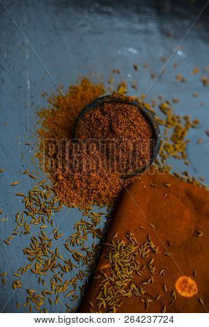 Close Up Of Powdered Cumin Or Zeera Or Jeera With Raw Cumin On Wooden Surface In A Clay Bowl On A Cl