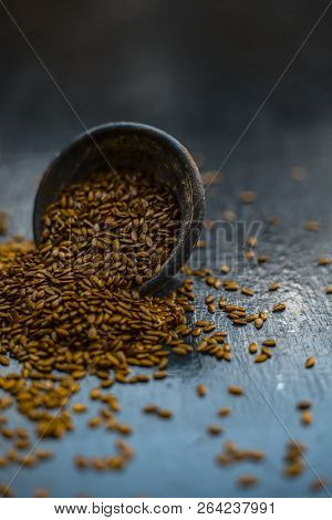 Close Up Of Ayurvedic Herb Alsi Or Adsi Or Flax Seed In A Black Colored Clay Bowl On Wooden Surface