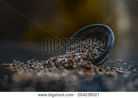 Close Up Of Ayurvedic Herb Alsi Or Adsi Or Flax Seed In A Black Colored Clay Bowl On Wooden Surface