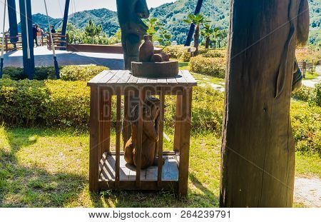 Samcheok, South Korea; September 25, 2018: Young Girl In Wooden Cage Chained To Phallic Shaped Statu