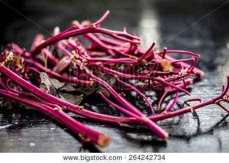 Close Up Of Raw Amaranth Leaves's Branches On Wooden Surface Without Its Leaves.