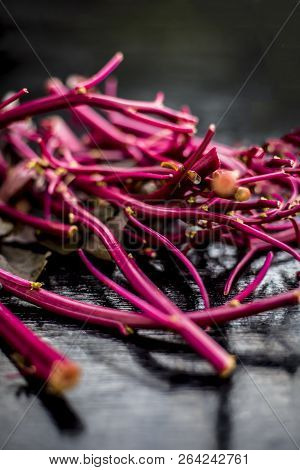 Close Up Of Raw Amaranth Leaves's Branches On Wooden Surface Without Its Leaves.
