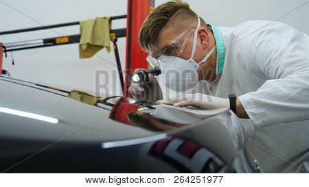 Professional Master After Polishing And Painting Cars, Checks The Flashlight Scratches, A Respirator