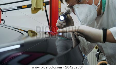 Professional Master After Polishing And Painting Cars, Checks The Flashlight Scratches, A Respirator