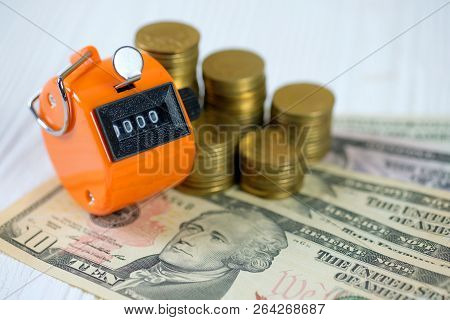 Tally Counter Or Counting Machine With 0000 Number, Coin And Banknote On White Wooden Table, Busines