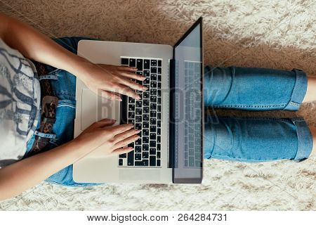 Woman Working On A Laptop. Female Using A Laptop Sitting On Floor, Searching Web, Browsing Informati