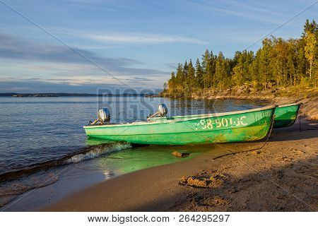Blue Sky And Two Green Pella Boats At Lake Beach