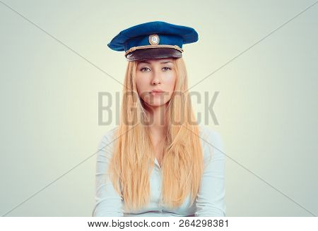 Young Blond Woman Wearing Blue Forage Cap And Looking Unemotionally At Camera