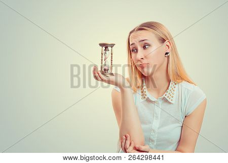 Blond Woman Making Pity Face Expression And Looking At Hourglass In Hope