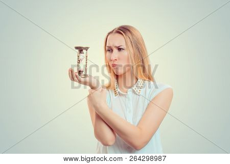 Young Blonde Holding Hourglass And Looking At It In Sad Thoughts Looking Unhappy