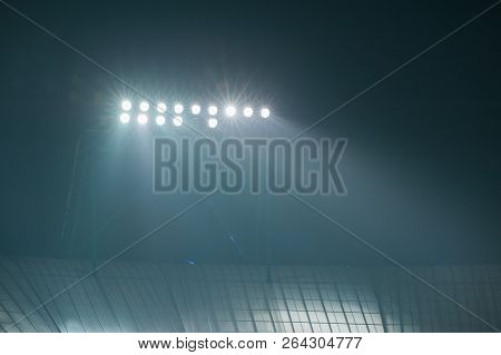 Hight Lighter. Light Tower Lit At A Football Stadium During Nigh Time.
