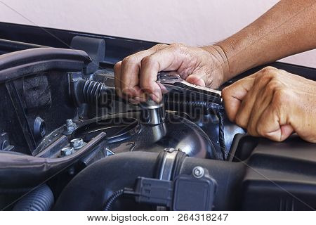 Hands of mechanic working in auto repair shopProfessional check oil filter and close oil filter cap