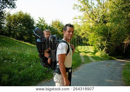 Father On A Walk With Kik In Child Carrier Backpack