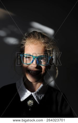 Contrast Portrait Of Cute Smiling Little Caucasian School Girl In Uniform And Glasses
