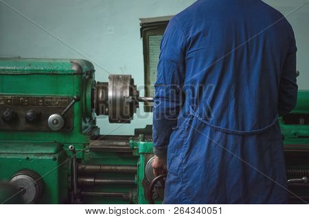 Turner Worker Is Working On A Lathe Machine In A Factory.