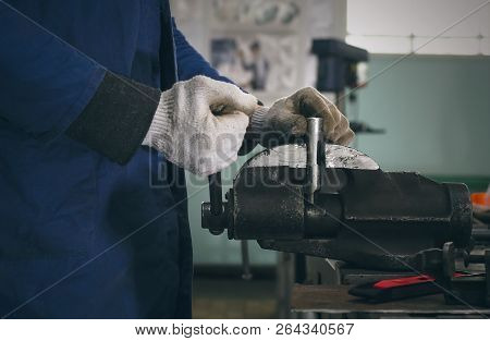 Man Worker Is Working With Iron Detail On Vise Grip On Blacksmith Table.