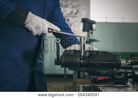 Man Worker Is Working With Iron Detail On Vise Grip On Blacksmith Table.