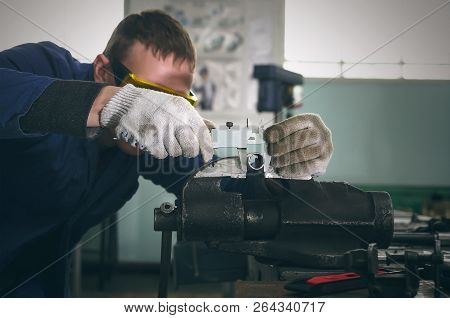 Man Worker Is Working With Iron Detail On Vise Grip On Blacksmith Table And Is Measuring A Diameter 
