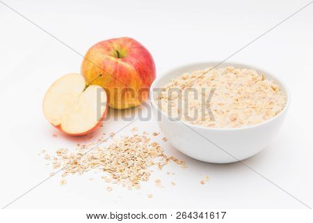 Oatmeal In White Bowl And Red Apple On White Background. Isolated On White. Healthy Food