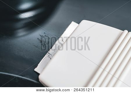 Cleaning A Ceramic Glass Cooktop With A Glass Scraper, High Angle View