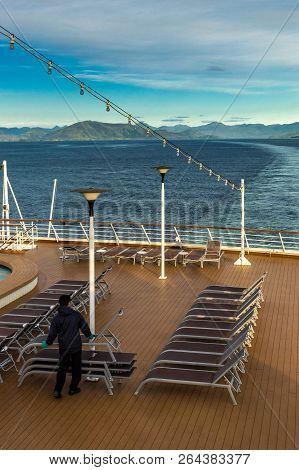 Inside Passage, Bc, Canada - September 13, 2018: Cruise Ship Worker Stacking Outdoor Loungers In The