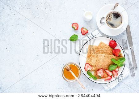 French Crepes Or Russian Blini With Fresh Strawberries, Honey, Coffee On Concrete Background. Health