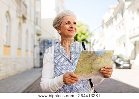travel, tourism and retirement concept - senior woman or tourist with map on city street