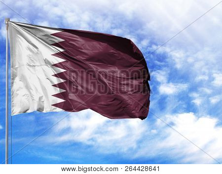 National Flag Of Qatar On A Flagpole In Front Of Blue Sky