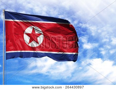 National Flag Of North Korea On A Flagpole In Front Of Blue Sky