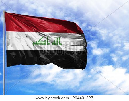 National Flag Of Iraq On A Flagpole In Front Of Blue Sky
