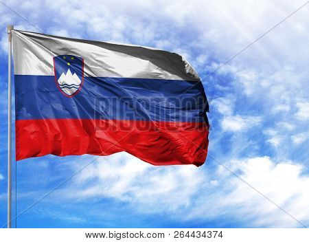 National Flag Of Slovenia On A Flagpole In Front Of Blue Sky