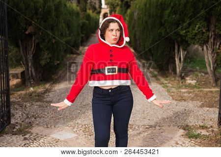 Christmas, Holidays, Humor And People Concept - Funny Happy Woman In Santa Suit Dancing Outdoors