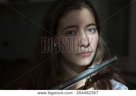 A Beautiful Woman Posing While Playing On A Flute