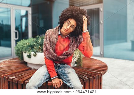 Young Fashionable Dressed Curly Black African American With Glasses Walks Through The Streets Agains