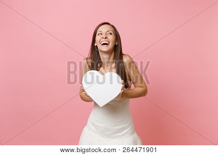 Portrait Of Laughing Happy Bride Woman In Beautiful White Wedding Dress Standing Holding White Heart