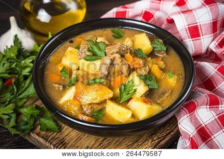 Goulash With Meat And Vegetables In Black Bowl. Beef Stew With Vegetables. European Cuisine.