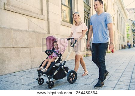 Family Taking A Walk Down The Street
