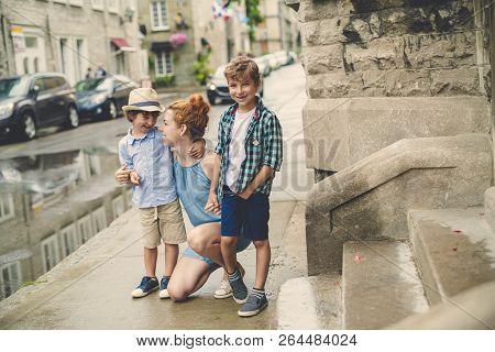 Mother With Her Two Son Outside In An Urban Street