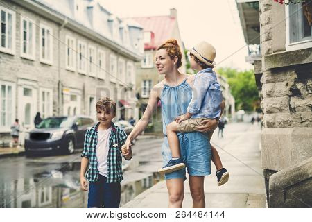 Mother With Her Two Son Outside In An Urban Street