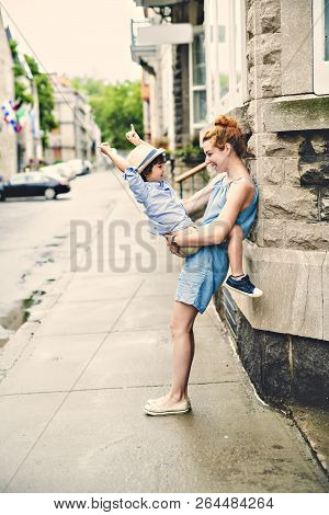 Mother With Her Son Outside In An Urban Street