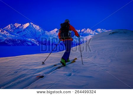Skitouring at sunset with amazing view of swiss famous mountains in beautiful winter powder snow of Alps. 