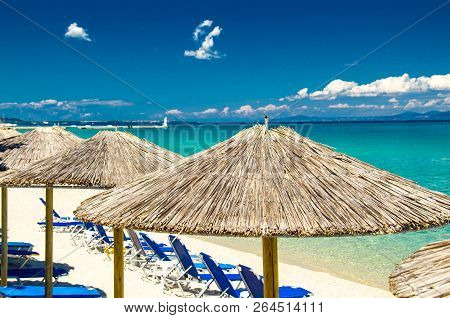 Yellow Umbrellas On The Beach, Blue Paradise Water Of Toroneos Kolpos Gulf, Blue Sky, White Clouds O