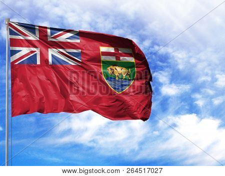 Flag Of Manitoba On Flagpole Against The Blue Sky