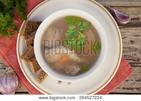 Clear Beef Broth, Bouillon In White Bowl And Vegetables On Wooden Table. Top View.