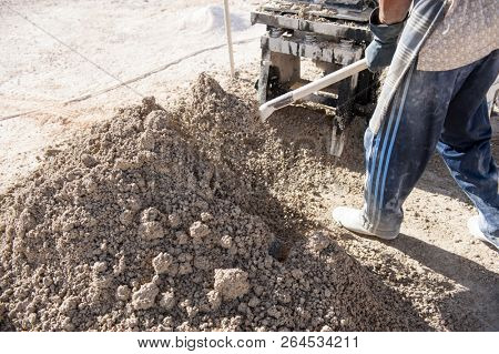 Man making brick from concrete mix