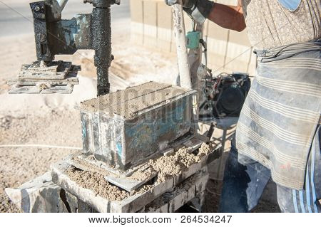 mMan making brick from concrete mix