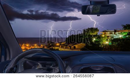 Looking Through A Car Windshield With View Of Lightning Storm Over The Sea